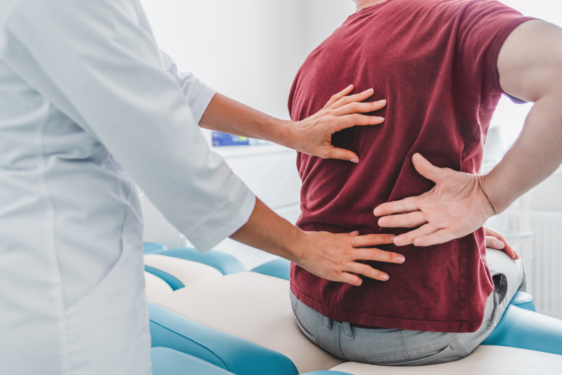 man with back pain seeking help from physician