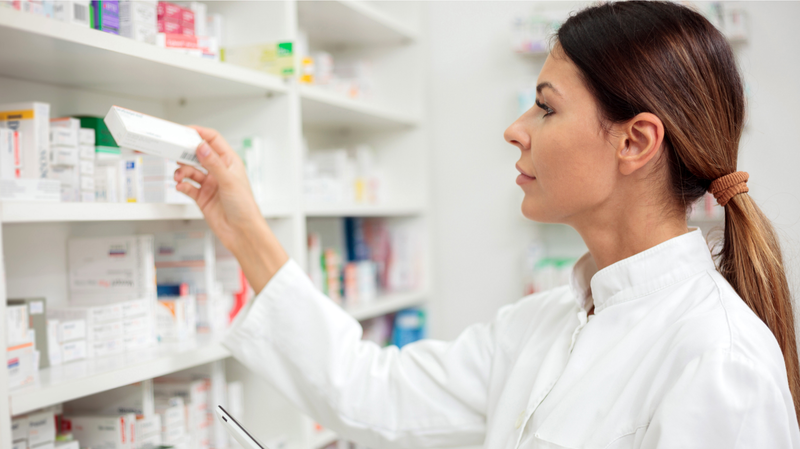 pharmacist grabbing medication from shelf