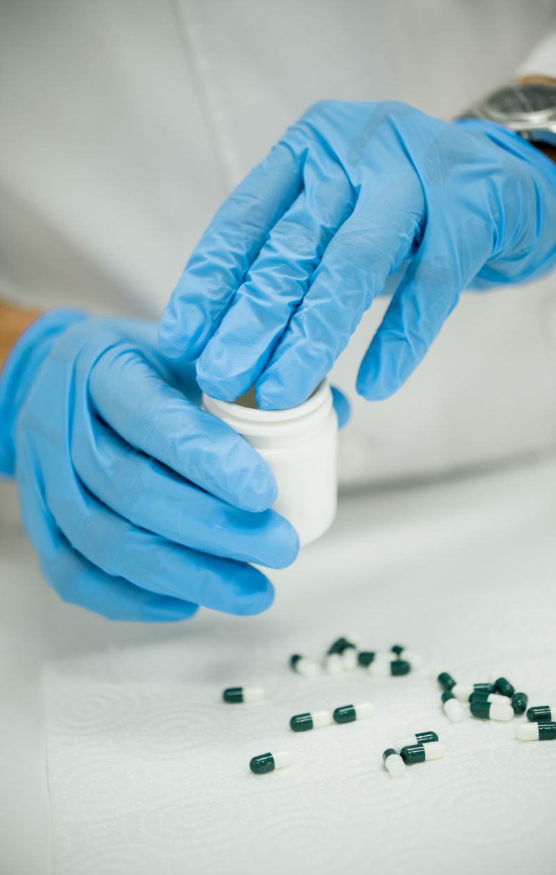 pharmacist putting capsules in bottle