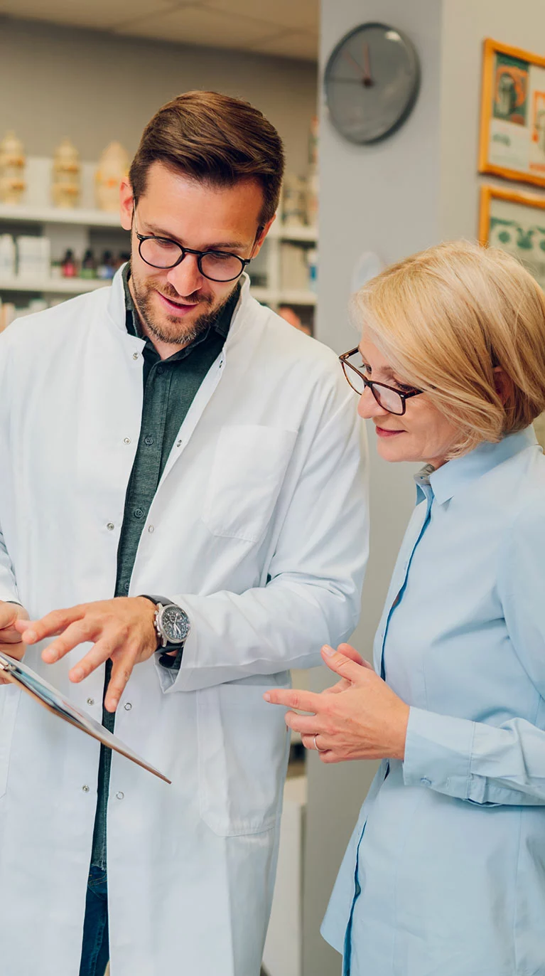 pharmacist with clipboard talking to patient